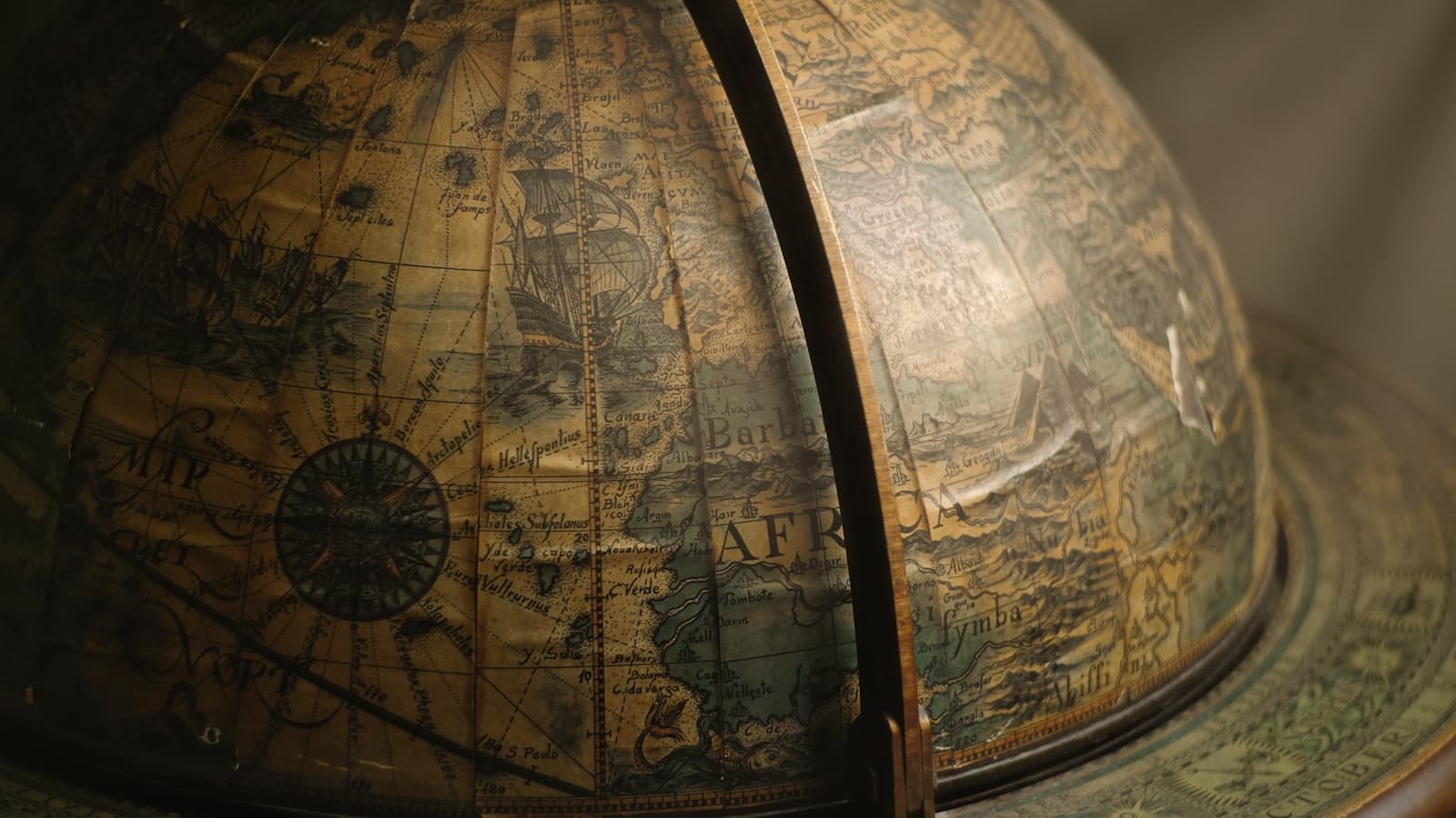 Detalhe de um globo terrestre antigo, com a costa da África, meridianos e rosas dos ventos gravadas